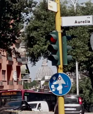 a traffic light and a street sign on a city street at 18 Vatican Penthouse in Rome