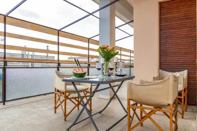 a table with flowers and chairs on a balcony at 18 Vatican Penthouse in Rome