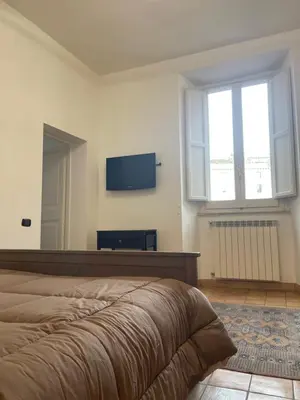 a bedroom with a bed and a flat screen tv at Casa Vannozza De' Cattanei in Rome