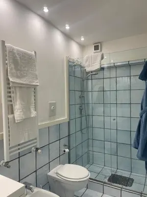 a bathroom with a toilet and a glass shower at Casa Vannozza De' Cattanei in Rome