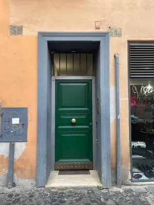 a green door on a building with graffiti at Casa Vannozza De' Cattanei in Rome