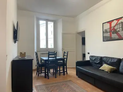 a living room with a black couch and a table and chairs at Casa Vannozza De' Cattanei in Rome