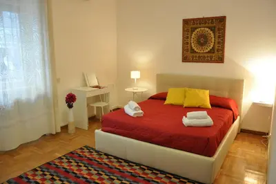 a bedroom with a bed with red sheets and yellow pillows at Big Home In Vatican in Rome