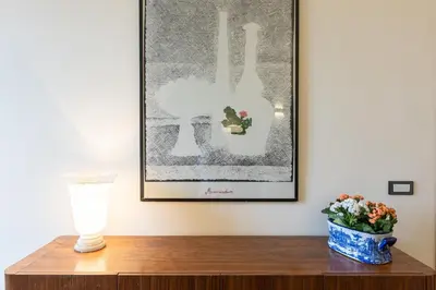 a table with a vase and a picture on the wall at Casa Prati by Rental in Rome in Rome