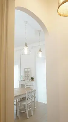a white dining room with a table and chairs at Armonia Mediterranea Apartments in Rome