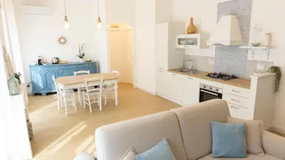 a living room and kitchen with a couch and a table at Armonia Mediterranea Apartments in Rome