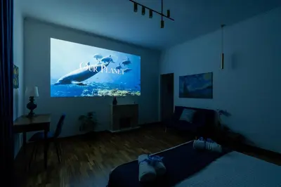 a living room with a large screen with a whale on it at Deluxe Apartment - Jacuzzi & Cinema, 500m to Metro B, 6-8 pax in Rome