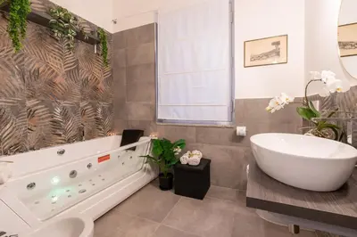a bathroom with a large tub and a sink at Deluxe Apartment - Jacuzzi & Cinema, 500m to Metro B, 6-8 pax in Rome