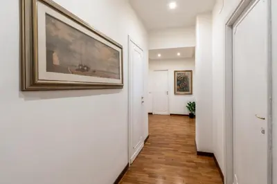 a hallway with white walls and a painting on the wall at Deluxe Apartment - Jacuzzi & Cinema, 500m to Metro B, 6-8 pax in Rome
