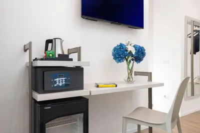 a desk with a tv and a vase of blue flowers at St Peter Museum in Rome