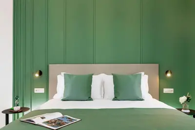 a green bedroom with a bed with a book on it at St Peter Museum in Rome