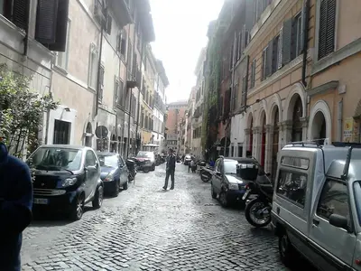 a man walking down a street with parked cars at Three bedroom apartment with a view in Monti in Rome