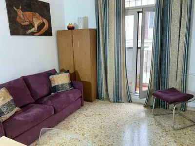 a living room with a purple couch and a window at Three bedroom apartment with a view in Monti in Rome