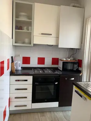 a kitchen with white cabinets and a stove top oven at Three bedroom apartment with a view in Monti in Rome