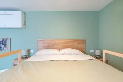 a bedroom with a large bed with a wooden headboard at Vatican Cozy Studio in Rome
