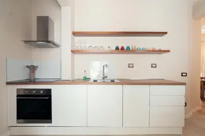a kitchen with white cabinets and a sink at Casa mia Navona Rooms in Rome