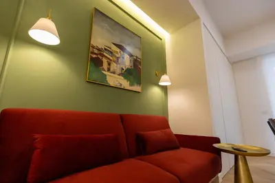 a living room with a red couch and a painting at Chigi Home in Rome
