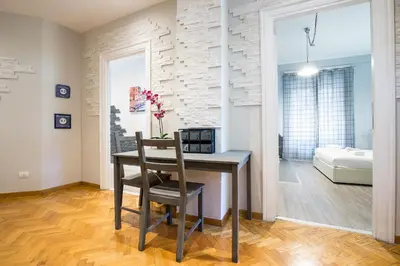 a room with a desk with a chair and a bedroom at Royal House Vaticano in Rome