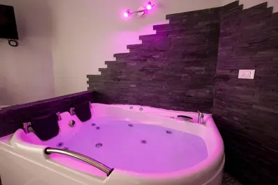 a pink bath tub in a bathroom with a brick wall at Royal House Vaticano in Rome