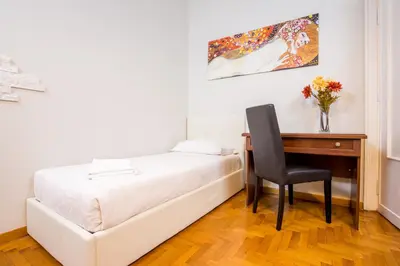 a bedroom with a desk and a bed and a chair at Royal House Vaticano in Rome