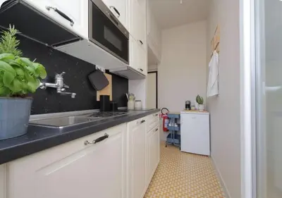 a kitchen with white cabinets and a sink at Caracalla Charming Terrace Loft in Rome