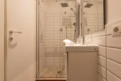 a white bathroom with a shower and a sink at Santa Maria Maggiore & Colosseo - Domus Aurea by Hôtea in Rome