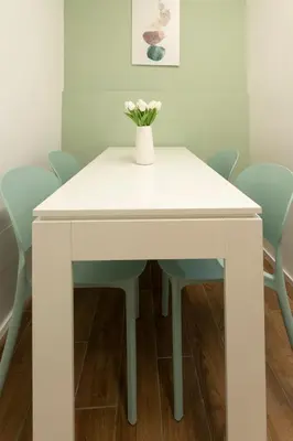 a white table with a vase of flowers on it at Santa Maria Maggiore & Colosseo - Domus Aurea by Hôtea in Rome