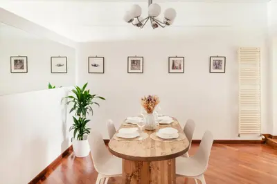 a dining room with a wooden table and white chairs at Leonina Art Loft in Rome