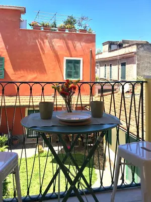 a table with two cups and flowers on a balcony at Borgo Capua in Rome