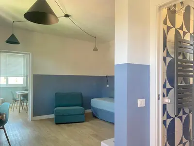 a room with a blue bed and a chair at Borgo Capua in Rome