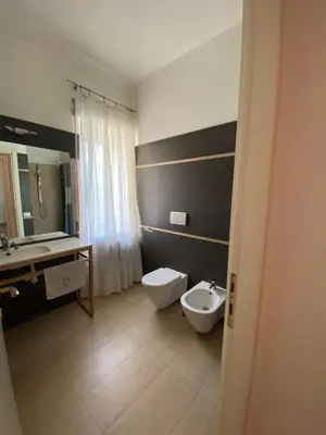 a bathroom with a toilet and a sink and mirror at Nina House Roma in Rome