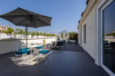 a patio with a table and chairs and an umbrella at Maria Luxury Apartment with City View Terrace in Rome