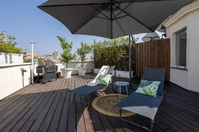 a patio with two chairs and a table with an umbrella at Maria Luxury Apartment with City View Terrace in Rome