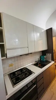 a kitchen with white cabinets and a stove top oven at My house in Rome