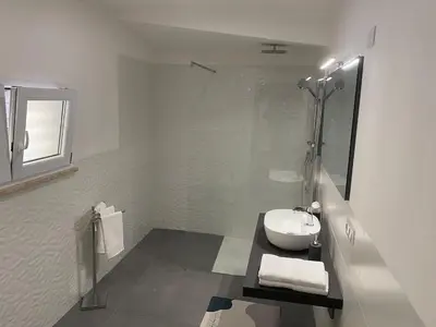 a white bathroom with a sink and a shower at Casa Bonosa in the Heart of Rome CISE 25369 in Rome