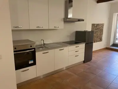 a kitchen with white cabinets and a black refrigerator at Casa Bonosa in the Heart of Rome CISE 25369 in Rome