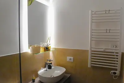a bathroom with a white sink and a mirror at Trevi Moonlight Apartment in Rome