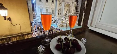 two champagne glasses and a plate of fruit on a table at Trevi Moonlight Apartment in Rome