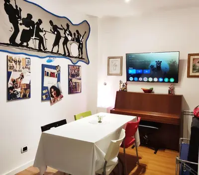 a dining room with a table and a piano at Holiday Jeans Apartment in Rome