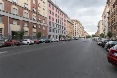 an empty city street with parked cars and buildings at Holiday Jeans Apartment in Rome