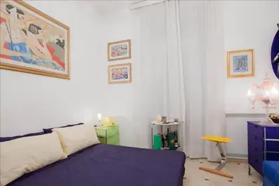 a bedroom with a bed and a dresser in it at Holiday Jeans Apartment in Rome