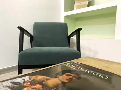 a book sitting on a table next to a chair at TrastEva nel cuore di Trastevere a San Cosimato in Rome