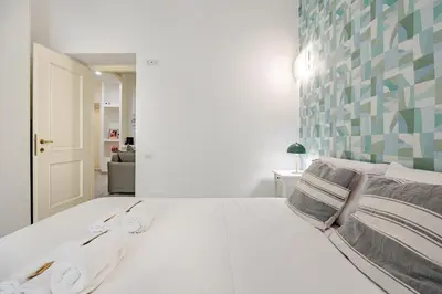 a bedroom with a white bed with towels on it at TrastEva nel cuore di Trastevere a San Cosimato in Rome