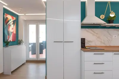 a kitchen with white cabinets and green walls at Tiburtina Station Rooftop Angel Joy with Private Terrace - Superattico con Terrazzo privato in Rome