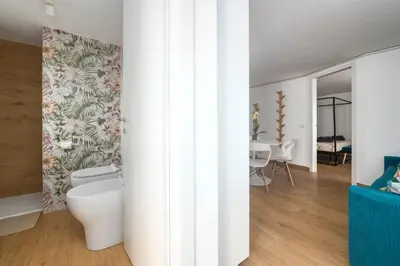a bathroom with a toilet and a dining room at Tiburtina Station Rooftop Angel Joy with Private Terrace - Superattico con Terrazzo privato in Rome