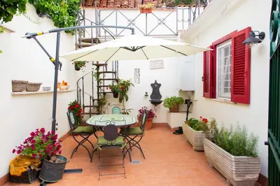 a patio with a table and an umbrella at Habemus Casam in Rome