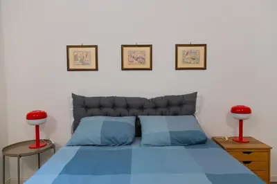 a bedroom with a blue bed and two red lamps at Habemus Casam in Rome