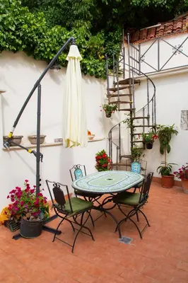 a patio with a table and chairs and a staircase at Habemus Casam in Rome