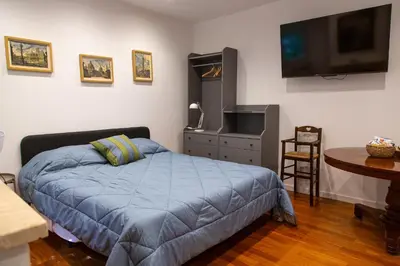 a bedroom with a bed and a flat screen tv at Habemus Casam in Rome