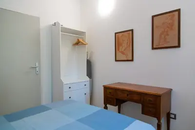 a bedroom with a bed and a desk and a cabinet at Habemus Casam in Rome